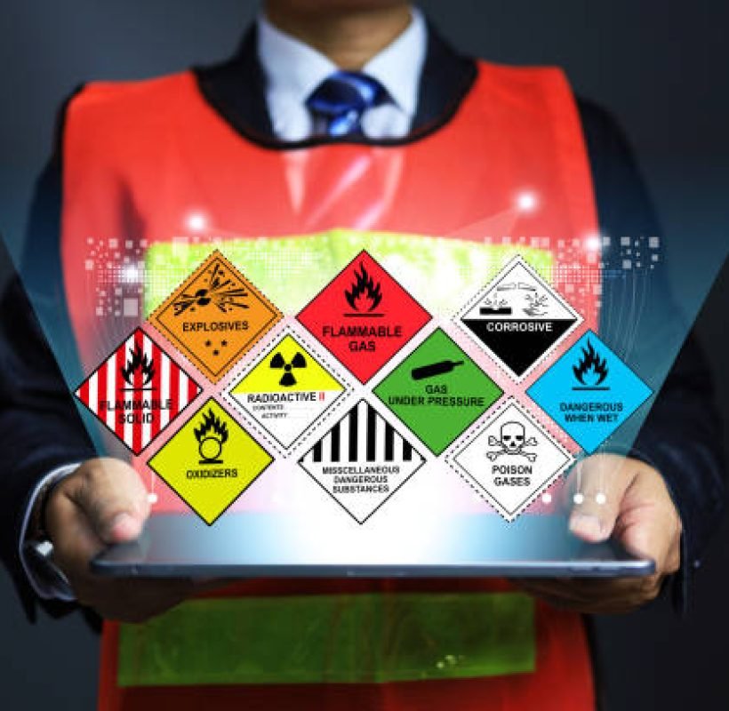 Hazardous substance concept chemical safety officer at dangerous goods warehouse holding tablet to arrange warning sign for different chemical to separate in sea transportation and air cargo shipment